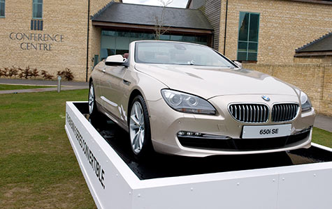 Photograph of a brand new BMW parked outside corporate training conference center