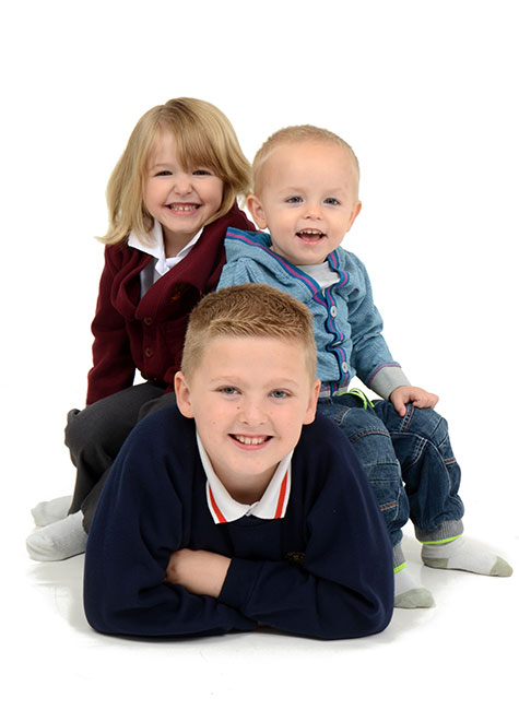 Three siblings posing for the camera in a family photo