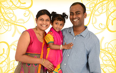 Portrait photo of a family smiling towards the camera